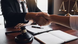 Two hands shaking over an agreement on the table, exemplifying how mediation works.