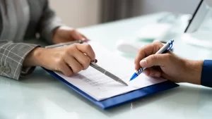 The hands of two people holding pens over an agreement, exemplifying how to win at mediation.