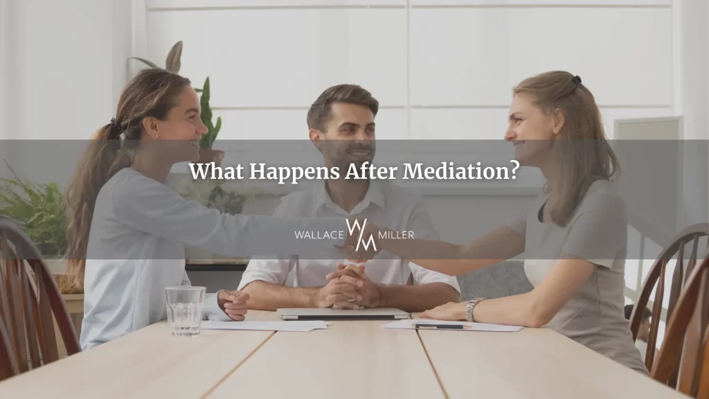 A mediator and two people sitting at a table and shaking hands, exemplifying what happens after mediation.