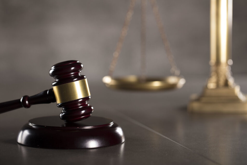 Symbols of law and justice: a wooden gavel and balance scales, relevant for legal representation in bi-cycle accidents in Chicago.